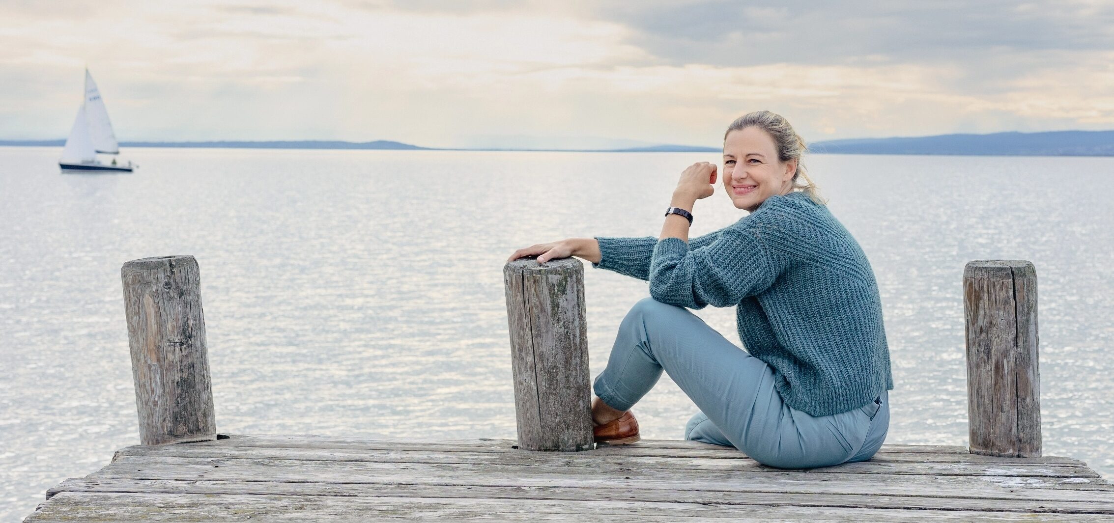 Nicole Nittnaus am Neusiedlersee. Neben ihr ein Segelboot.